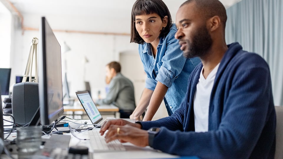 a man and a woman looking at a computer screen